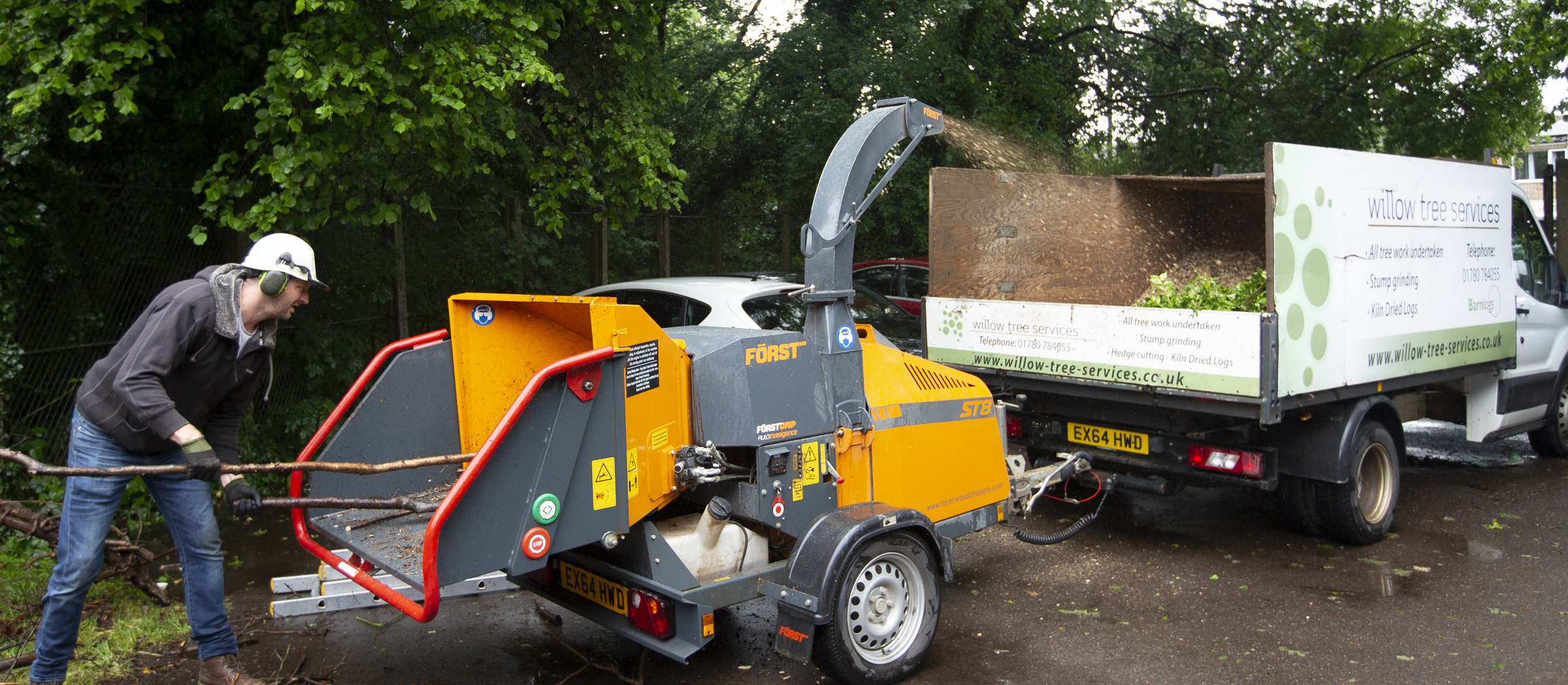 Picture of the ground crew putting trees through an industrial shredder.